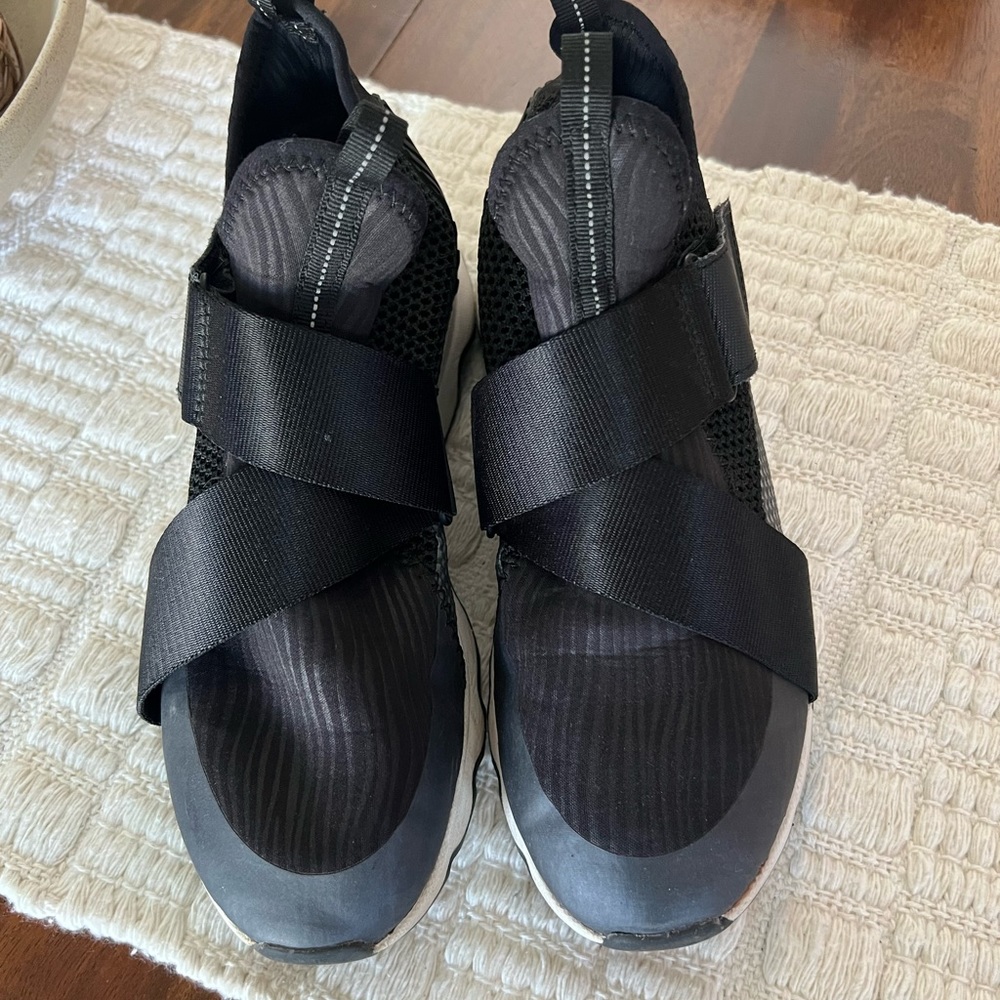 Woman’s black kinetic tennis shoes